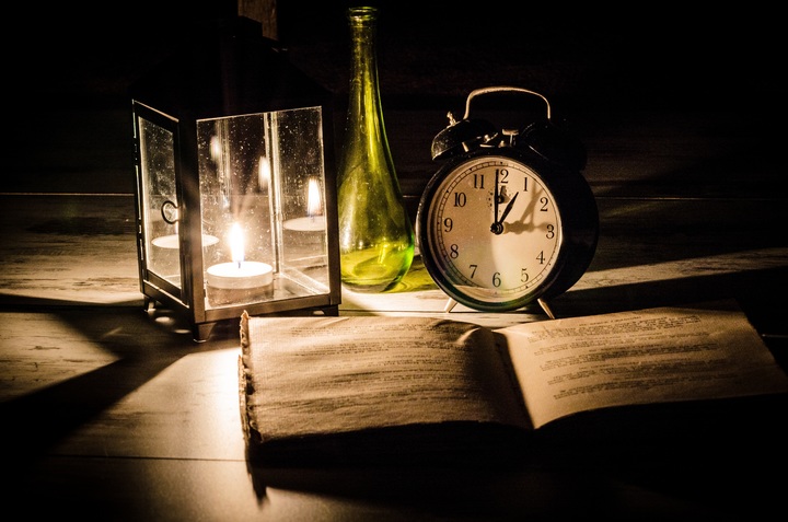 Light shining on Bible with clock